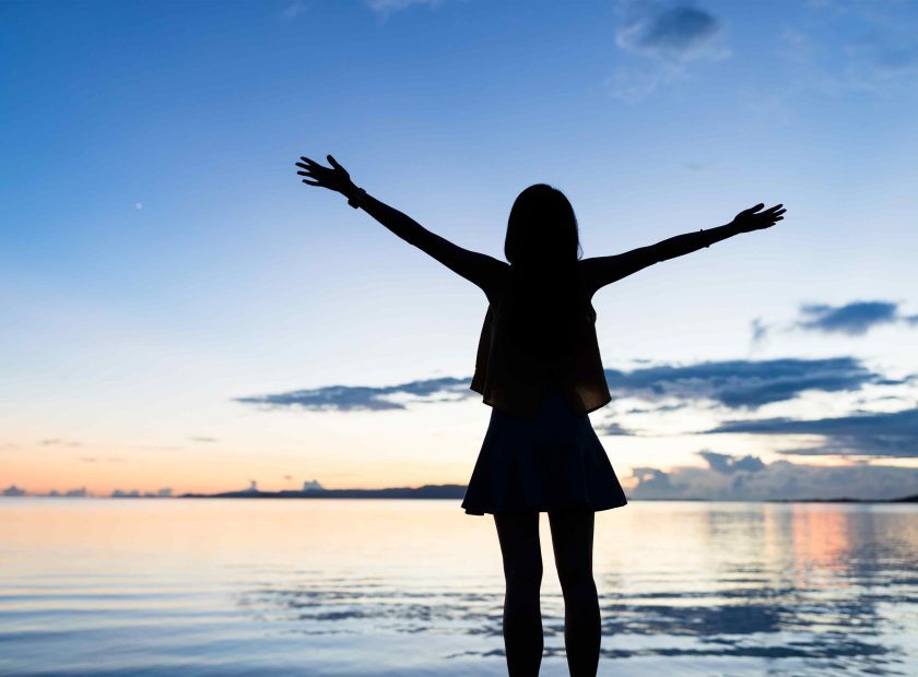 silhouette-of-woman-raising-hand-at-sunset-time